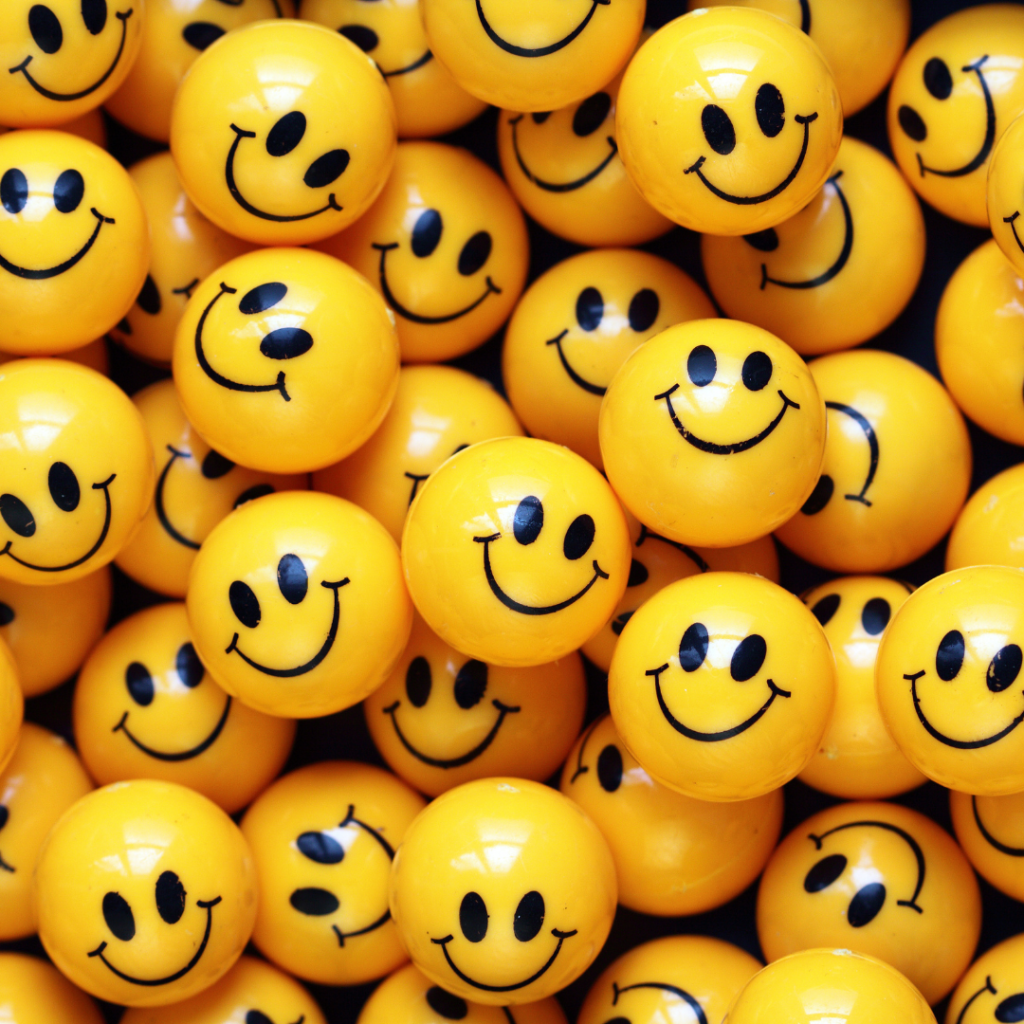 A picture of lots of close up yellow balls with black smiley faces. 
